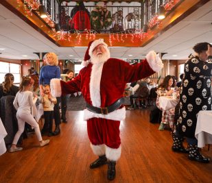 Santa Claus poses for a photo on the Riverboats at the Gateway Arch during a PJs and Pancakes Cruise.