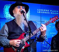 Musician Jeff Chapman playing a guitar and singing