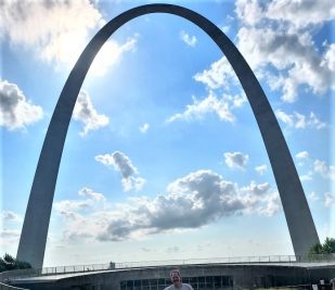 Ranger Frank of Gateway Arch National Park standing in front of the Arch one morning before beginning his running tour.