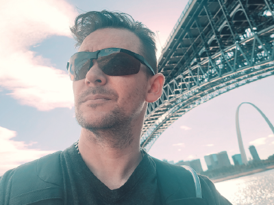 Male looking off camera with the Eads Bridge and Gateway Arch in the background