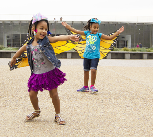 Two girls wearing butterfly wings at the Gateway Arch grounds